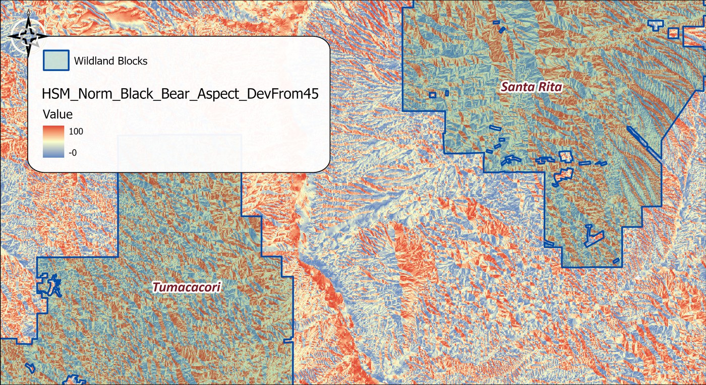 The normalized raster HSM_Norm_Black_Bear_Aspect_DevFrom45 over the two wildland blocks in a blue-to-red color ramp from 0 to 100, northeast-facing slopes in red and orange, southwest-facing slopes in blue, forming a striped pattern along every ridge and valley