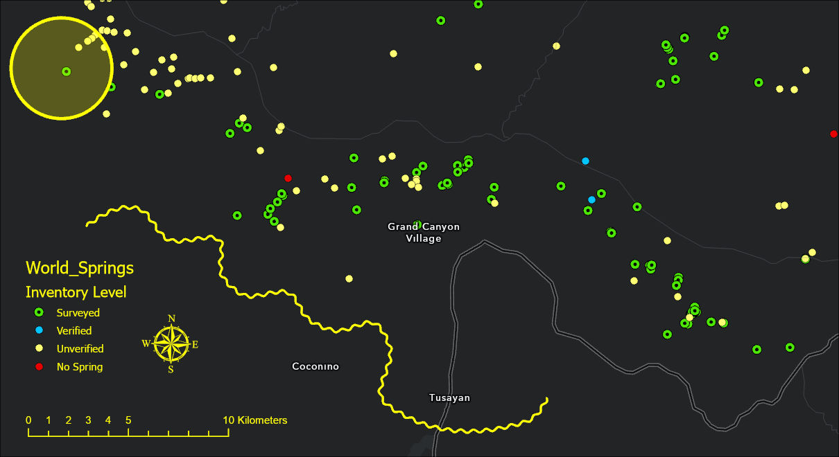 The same layout after the tool: the legend text, the scale bar, the north arrow, the circle and the freehand line are now bright yellow, and the circle's fill is a translucent yellow through which the dark ground and the springs still show