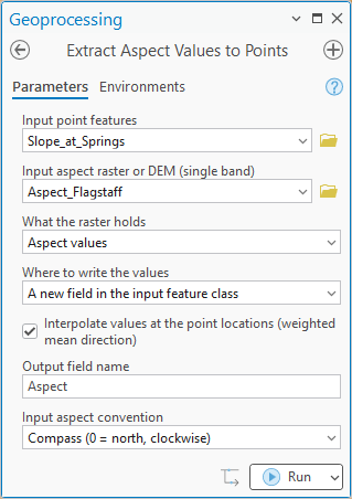 The Extract Aspect Values to Points pane: Input point features Slope_at_Springs, Input aspect raster or DEM Aspect_Flagstaff, What the raster holds set to Aspect values, Where to write the values set to A new field in the input feature class, Interpolate values checked, Output field name Aspect, Input aspect convention Compass (0 = north, clockwise); there is no output name row.