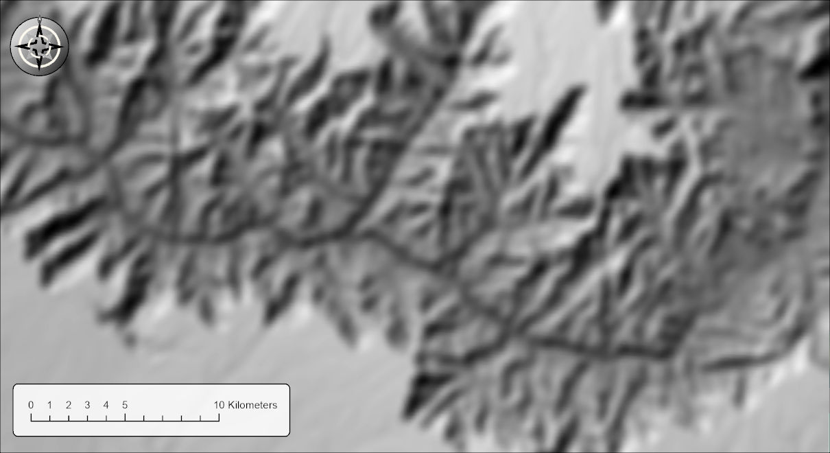 A hillshade of the Grand Canyon blurred after it was computed: the same pattern of light and dark as the full-detail hillshade, but out of focus, with every edge soft and the cast shadows spread into dark, soft-edged patches