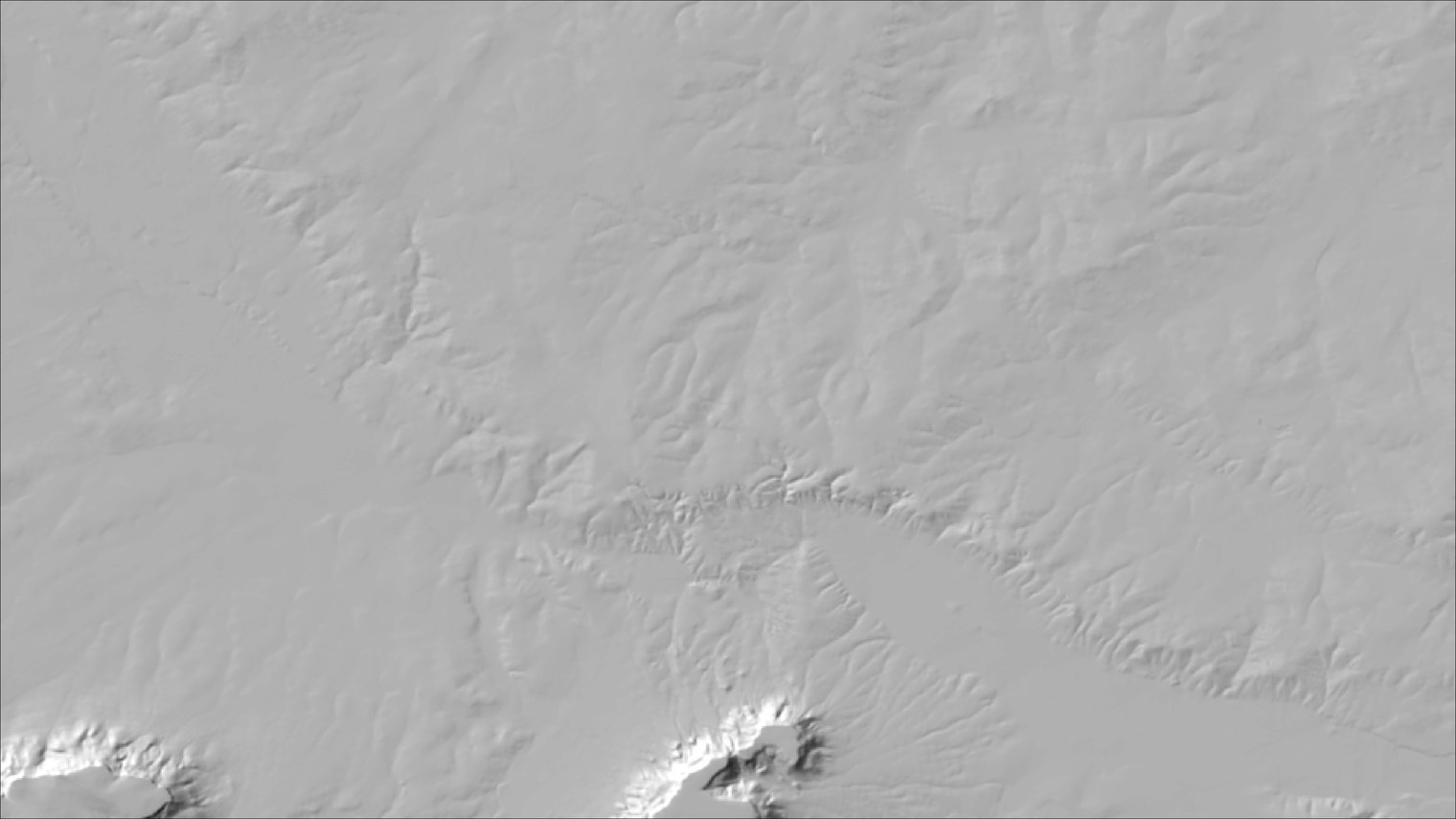 A normal gray hillshade of gently rolling country with two small buttes at the bottom edge; the low relief shows as a fine pattern of drainages and scarps