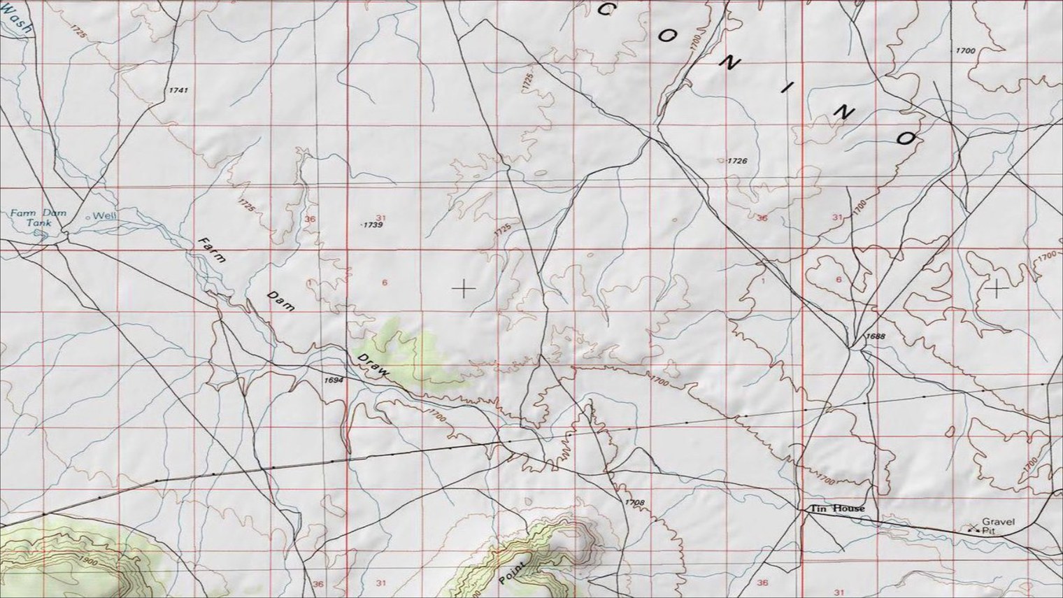 The same area on the USGS topographic map layer: brown contours, blue drainages, black roads, a red section grid and place names, drawn over a very soft, pale shaded relief in which only the broadest forms of the terrain can be made out