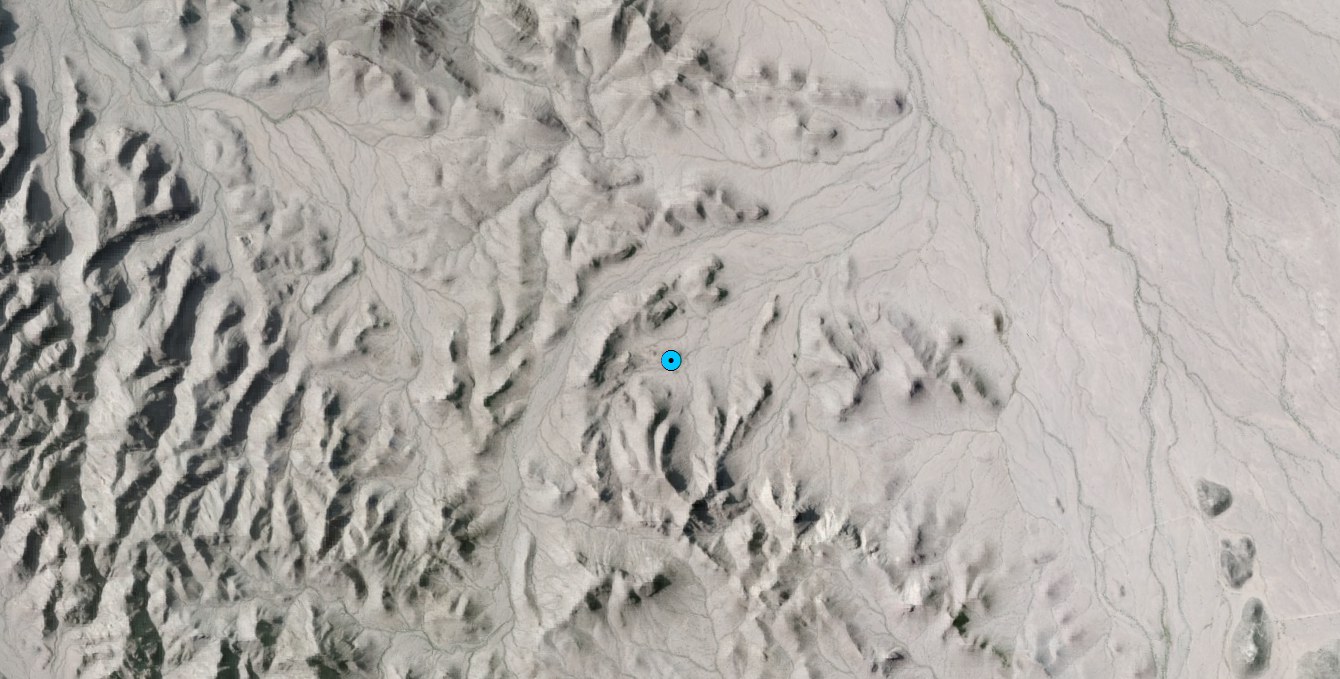 Aerial imagery of desert terrain with a single blue dot marking a spring